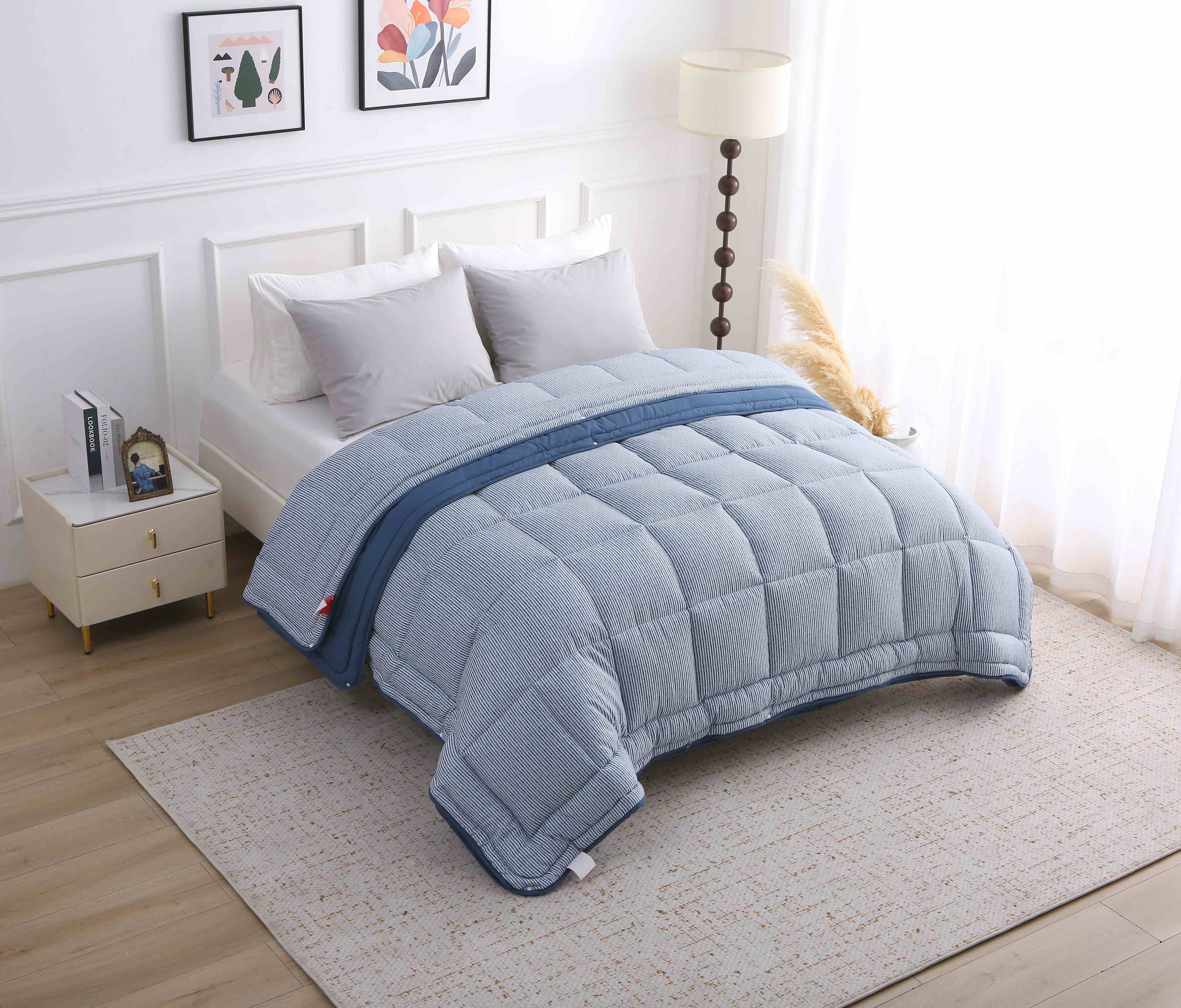 Zijdelingse opname van het blauwe 4-seizoenen dekbed zonder overtrek, met zicht op het stiksel en de lagen