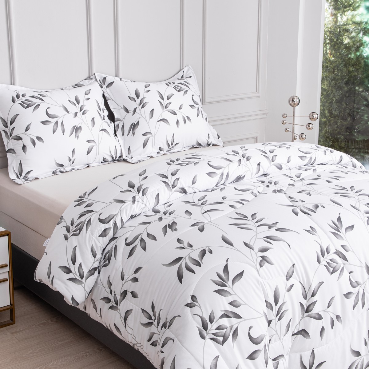 Zijaanzicht van het bed met het ritsbare vierseizoenen dekbed Nora met bladpatroon en strakke afwerking.