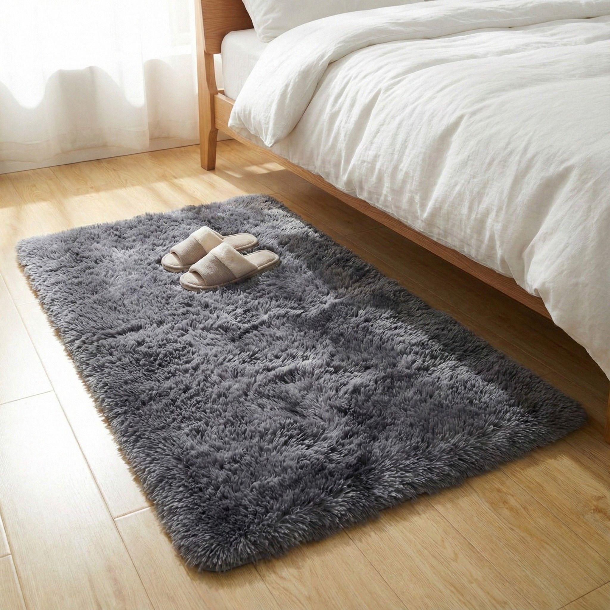 Hoogpolig donkergrijs vloerkleed van 60×90 cm naast het bed, zacht voor warme voeten en met antislip onderzijde