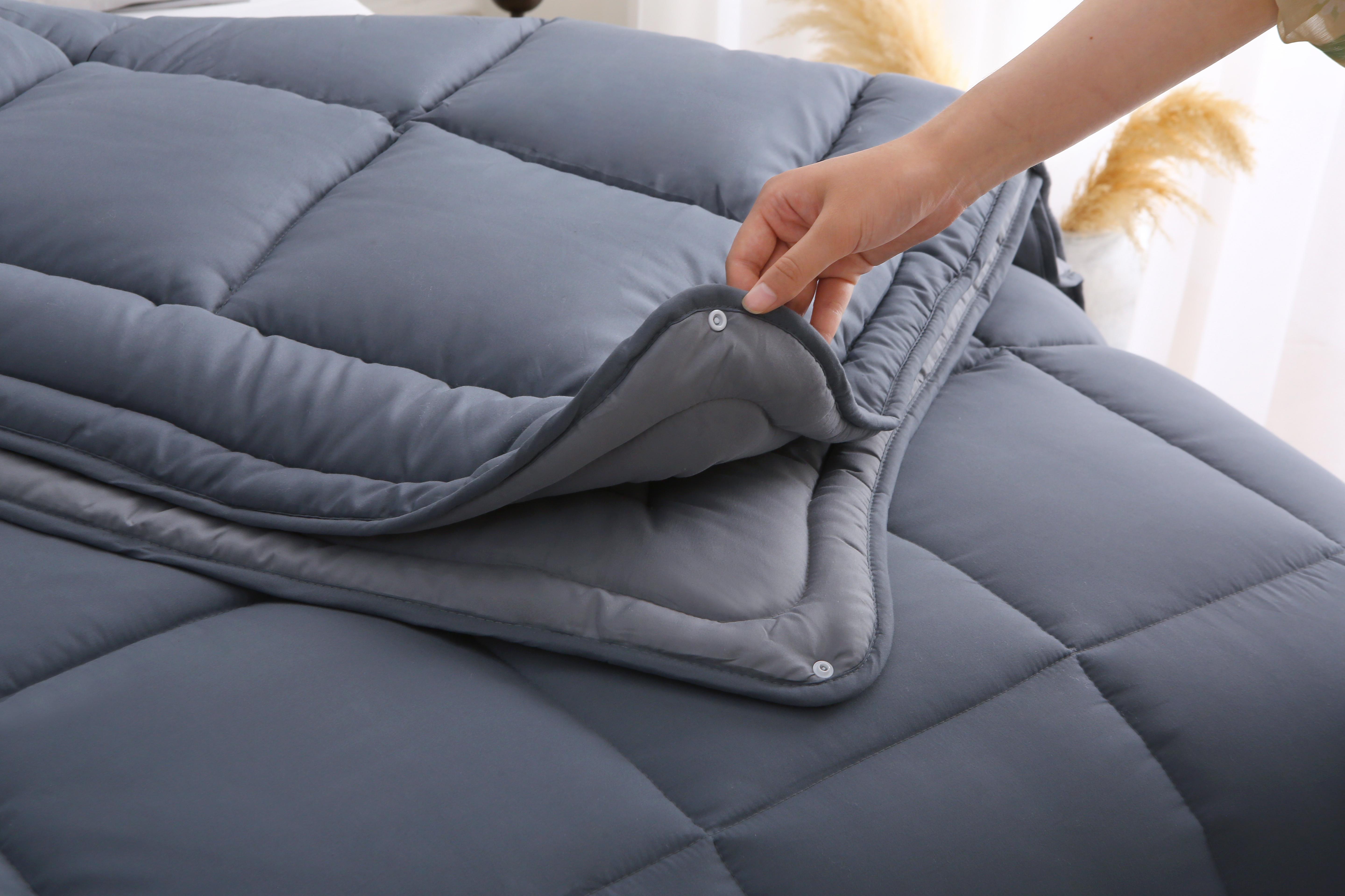 Hand bevestigt delen van 2-delig antraciet dekbed zonder overtrek met drukknopen