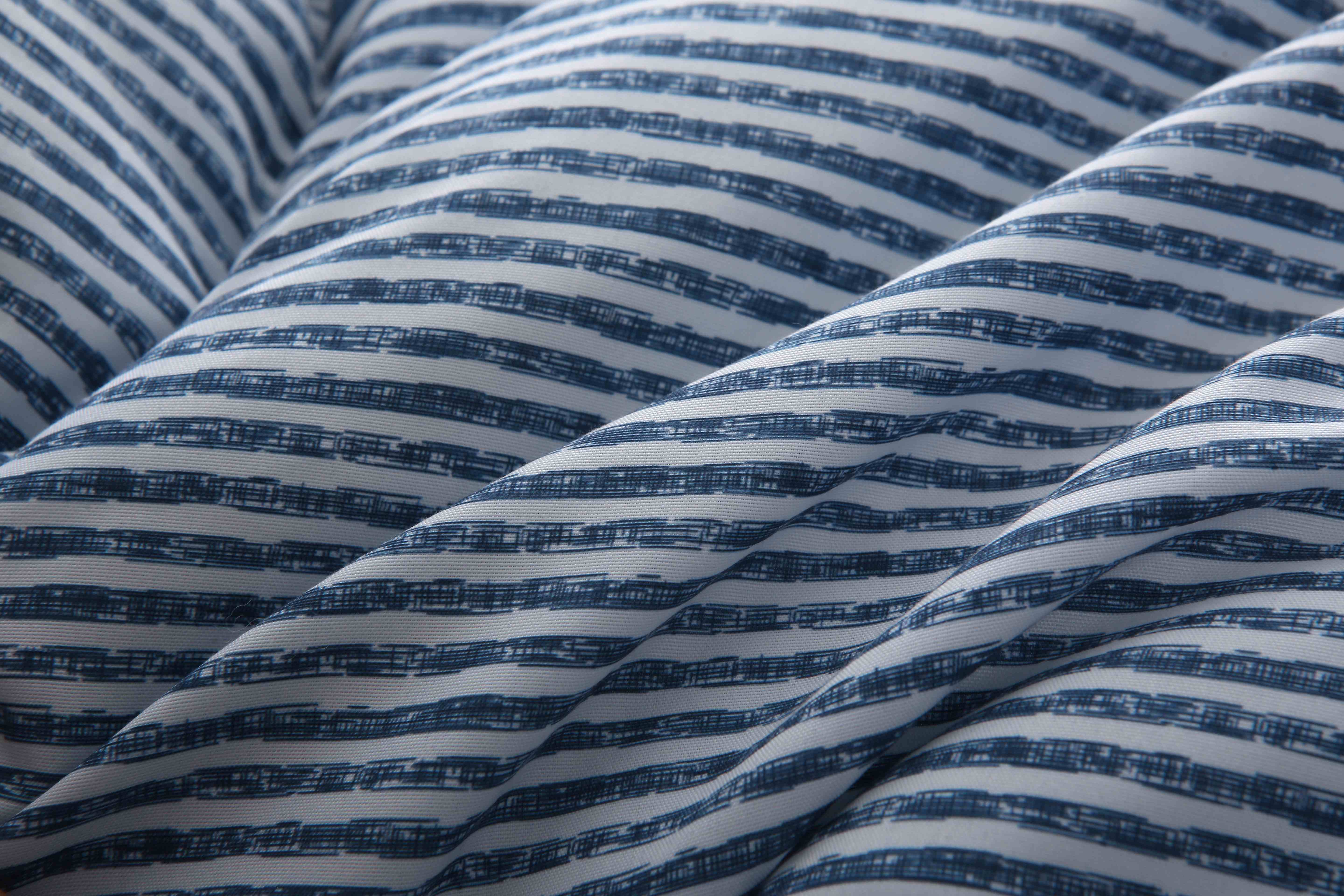 Close-up van de zachte, ademende microvezel tijk van het blauw-wit gestreepte 4-seizoenen dekbed zonder overtrek – huidvriendelijk en sneldrogend