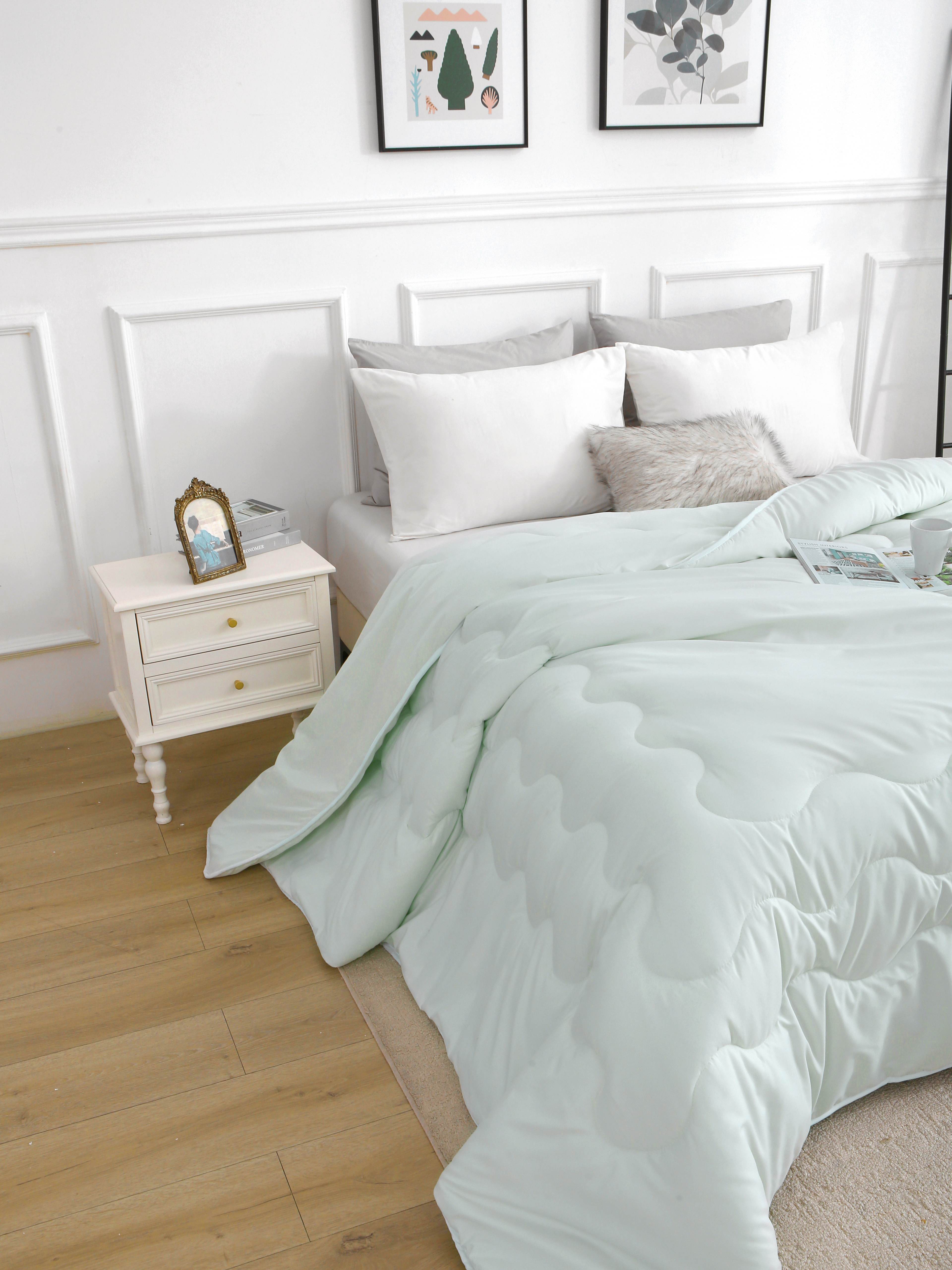 Lichtgroen verkoelend dekbed zonder overtrek opgemaakt op bed, ideaal bij nachtzweten en warme zomernachten