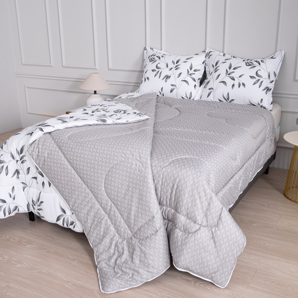 Dekbed Nora waarvan de twee lagen deels losgeritst zijn van elkaar bij dit dekbed met vaste overtrek met bladmotief.