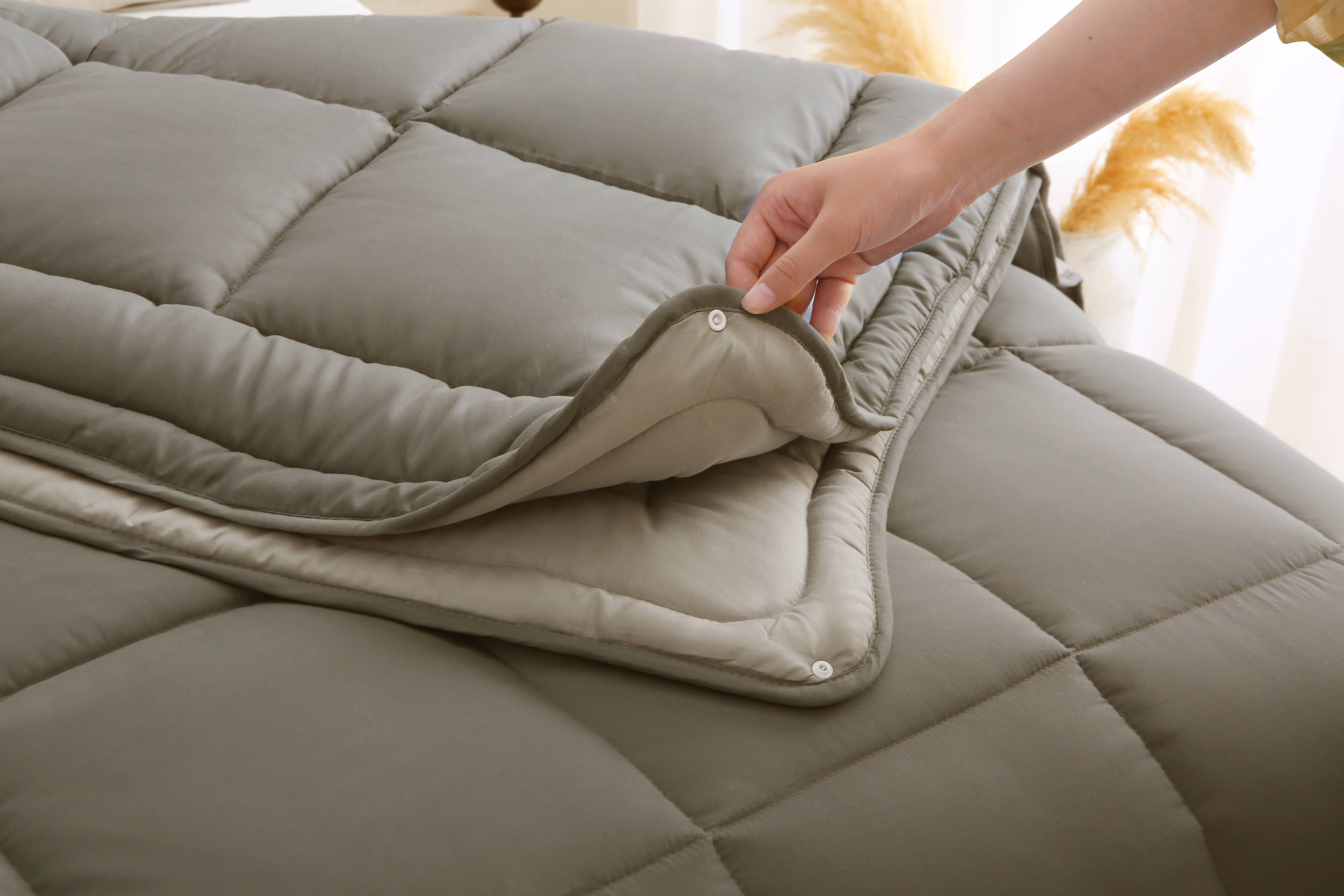 Close-up van de knopenbevestiging van een taupe 4-seizoenen dekbed